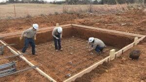 Crew tying rebar inside the formwork for a concrete equipment foundation