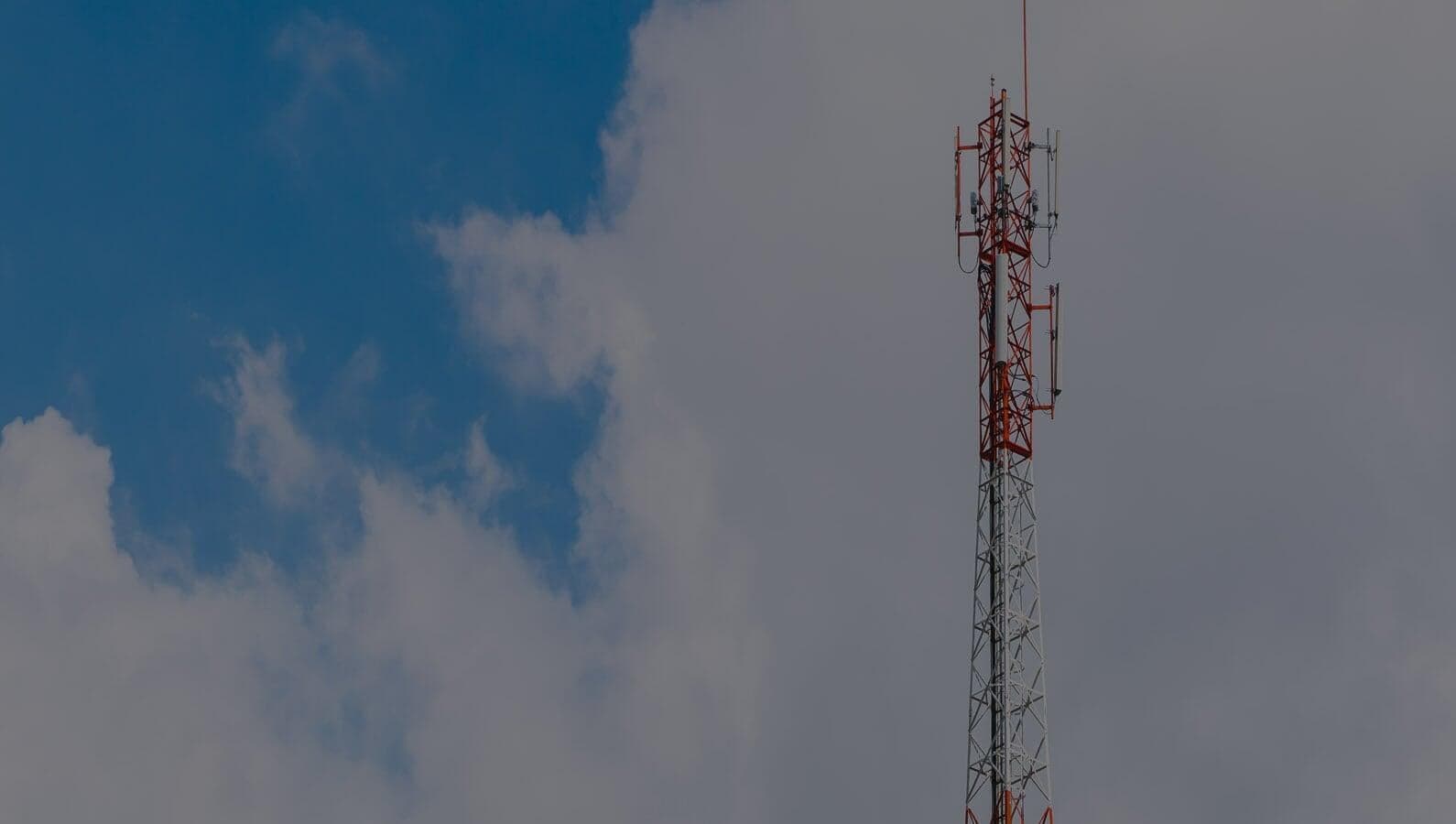 Communications tower rising above open sky at an Alturex job site